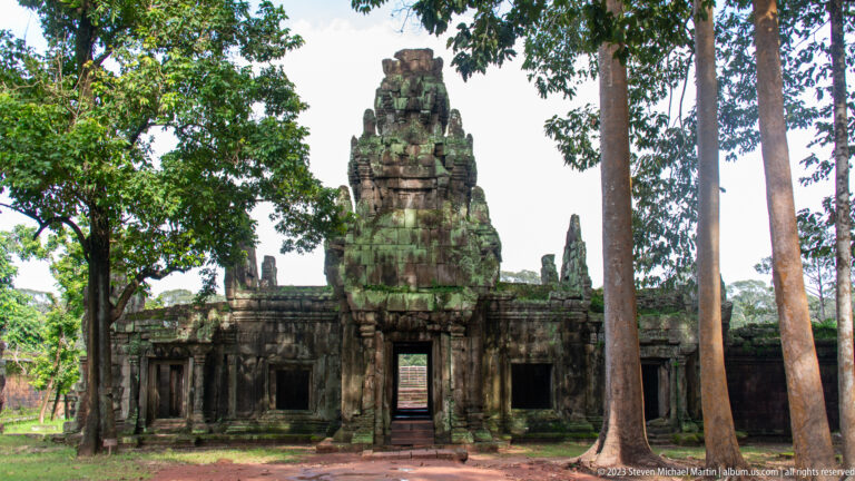 Wider frontal view of the same gopura and side galleries at Angkor Thom.