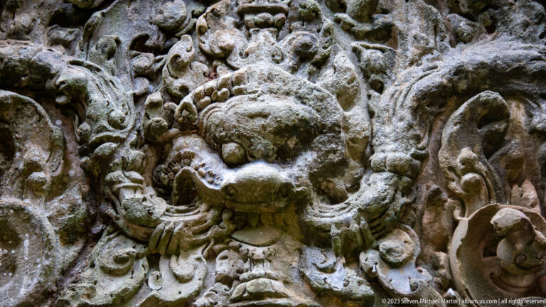 Close carved monster face with bulging eyes and open mouth at Angkor Thom.