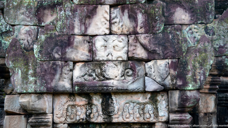 Close wall relief of an elephant head and decorative bands at Angkor Thom.