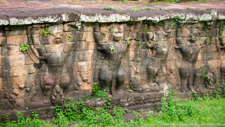 Close row of elephant trunks and legs carved in stone at Angkor Thom.