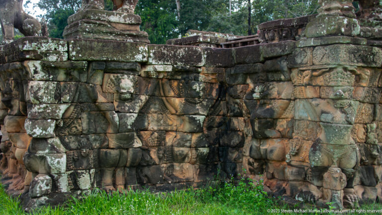 Weathered terrace wall with projecting elephant forms at Angkor Thom.
