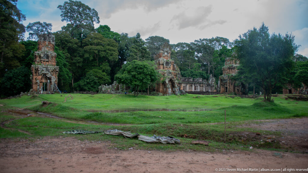 Wide grassy royal square with distant terrace ruins at Angkor Thom.