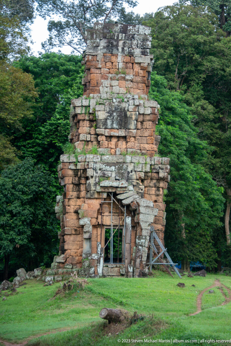 Small red-brick tower with a dark doorway and pale lintel at Angkor Thom.