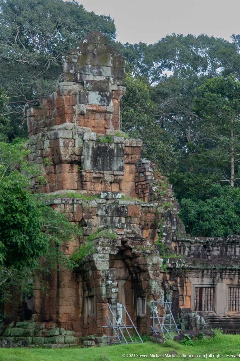 Oblique view of a larger brick ruin with arched opening at Angkor Thom.