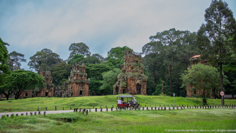 Wide lawn with isolated brick and sandstone towers at Angkor Thom.
