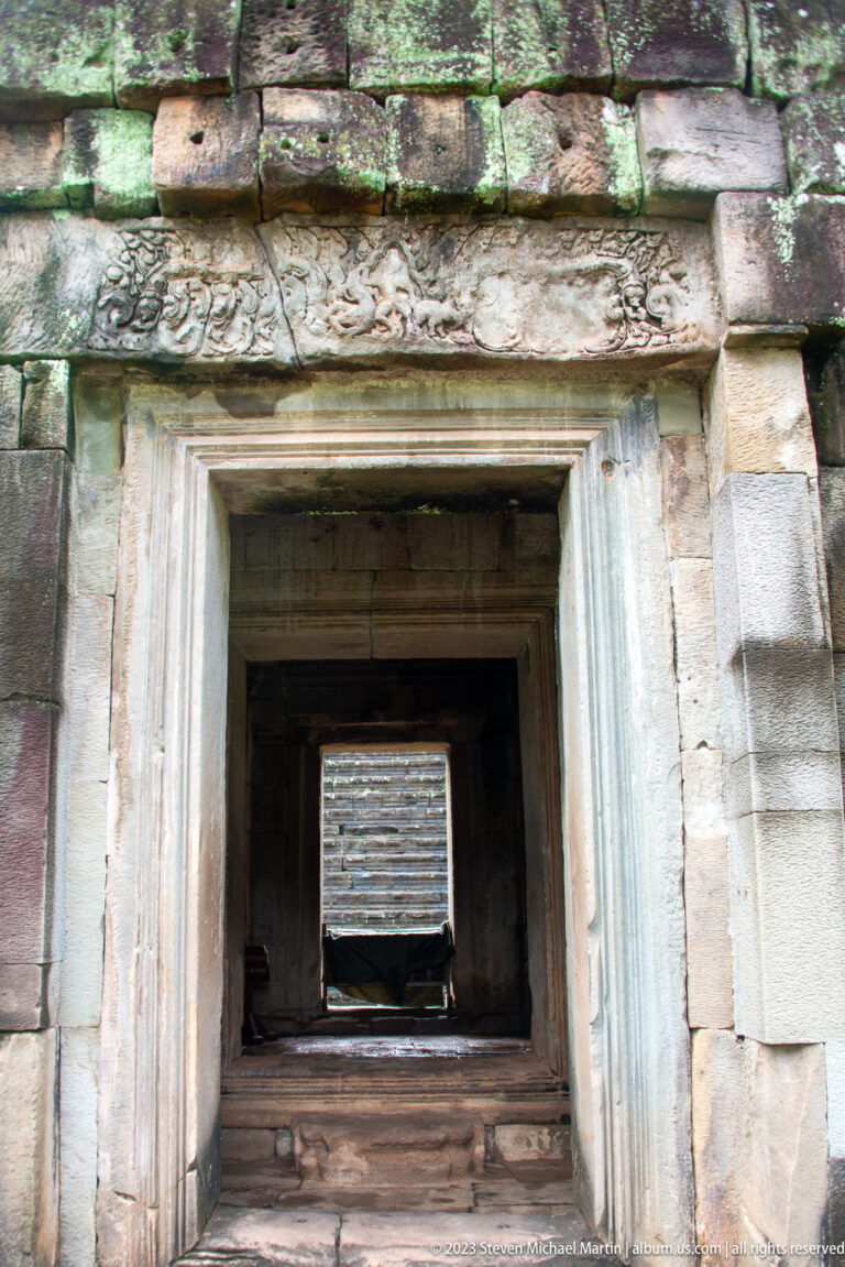 Nested rectangular doorways aligned through a stone gallery at Angkor Thom.