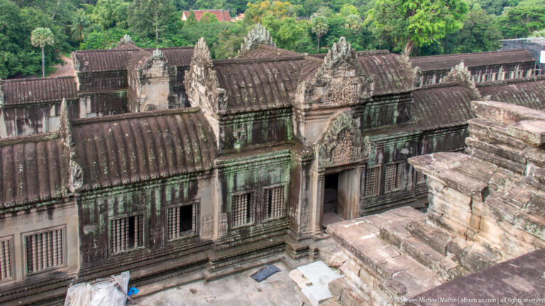 Elevated view across weathered tiled gallery roofs and upper courtyards at Angkor Wat.