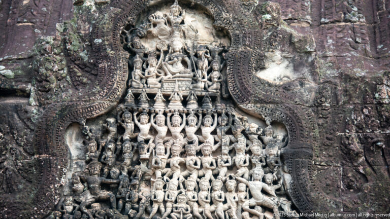 Close triangular pediment filled with repeated seated figures at Angkor Wat.