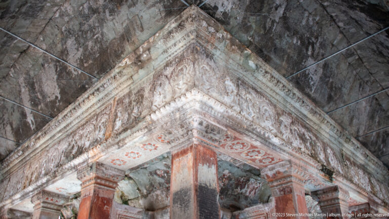 Painted or stained interior ceiling corner with red and pale decorative bands at Angkor Wat.