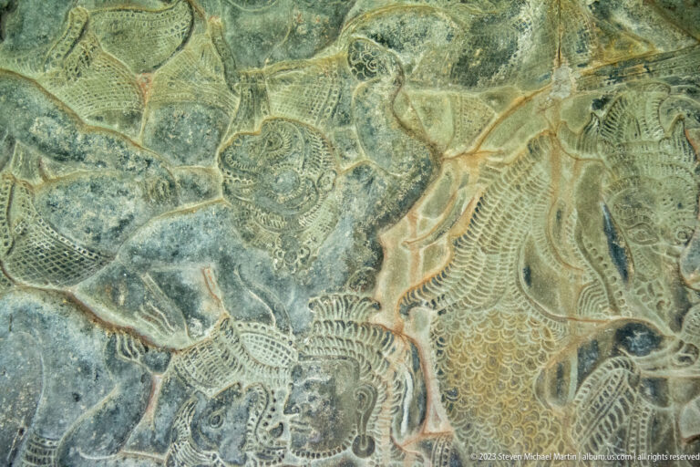 Faint relief of intertwined figures and animals at Angkor Wat.