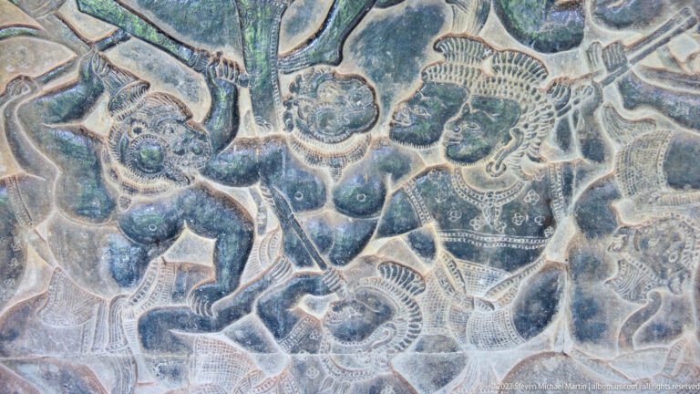 Close crowded relief of human and animal forms with pale outlines at Angkor Wat.