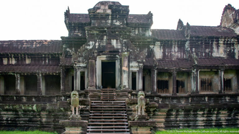Frontal long gallery pavilion with central stair and dark colonnade at Angkor Wat.