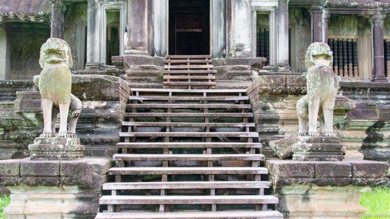 Closer central staircase flanked by pale guardian lions at Angkor Wat.