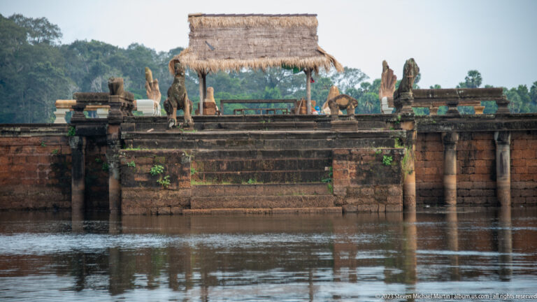Low waterside pavilion or platform with thatched canopy and decorative objects at Angkor Wat.