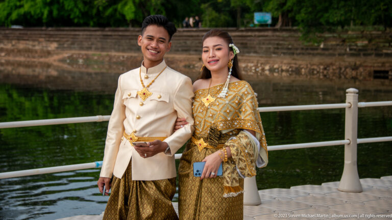 Young couple in formal Cambodian dress posing together on the causeway at Angkor Wat.