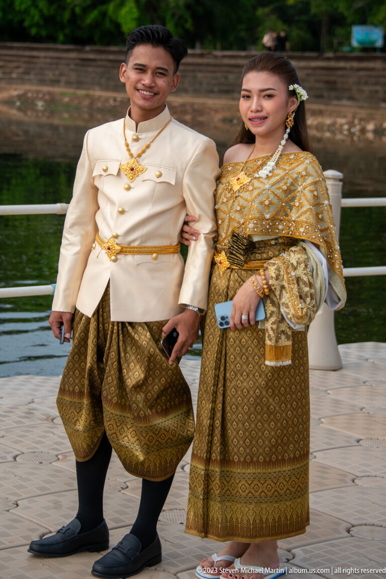 Close crop of the couple’s gold garments and clasped hands at Angkor Wat.