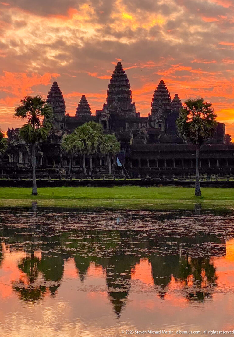 Dark close sunset silhouette of the towers against vivid orange-red sky at Angkor Wat.