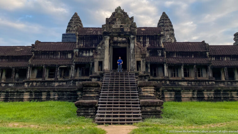 Frontal western entrance with steep temporary stair and visitor in doorway at Angkor Wat.