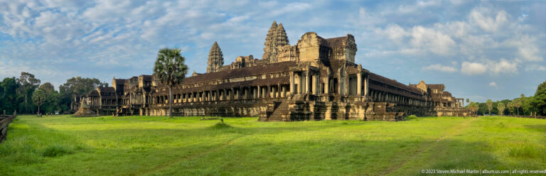 Second medium view of the same gallery corner across grass at Angkor Wat.