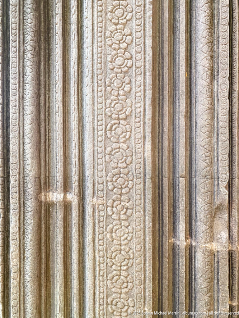 Close vertical decorative doorway molding with repeated floral and bead patterns at Angkor Wat.