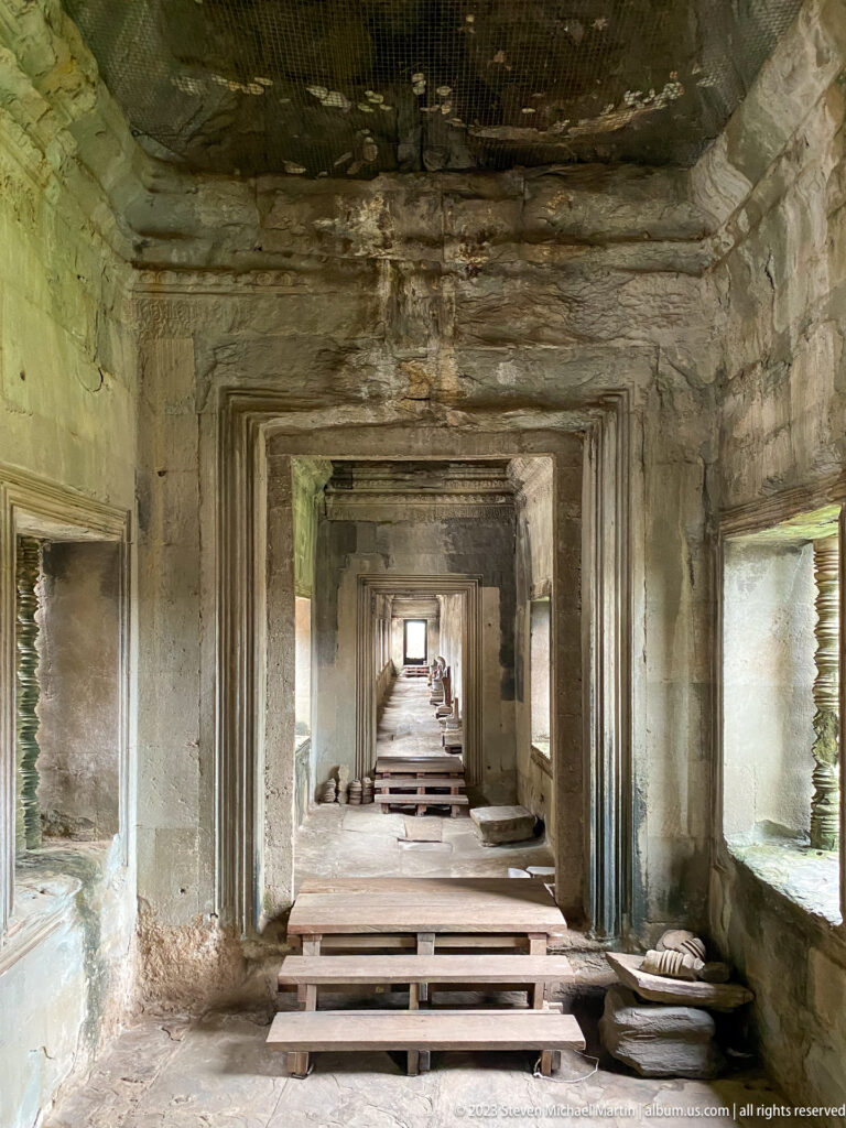 Long aligned sequence of rectangular interior doorways and a small shrine at the far end at Angkor Wat.