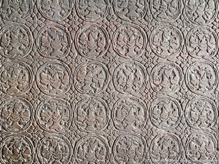Second repeating medallion panel with darker weathering and stronger relief at Angkor Wat.