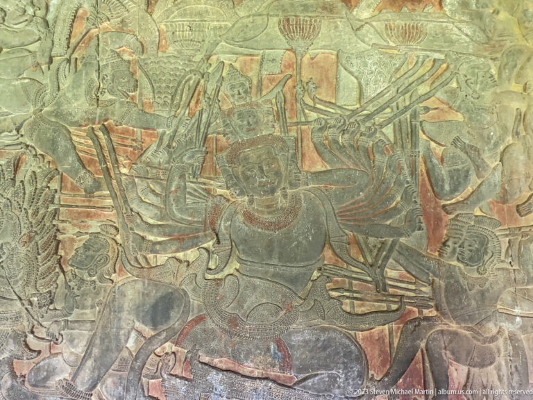 Colored processional or battle scene with several standing figures and weapons at Angkor Wat.