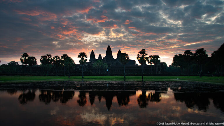 Angkor Wat silhouette reflected almost symmetrically in the still northern reflecting pool at sunrise at Angkor Wat.