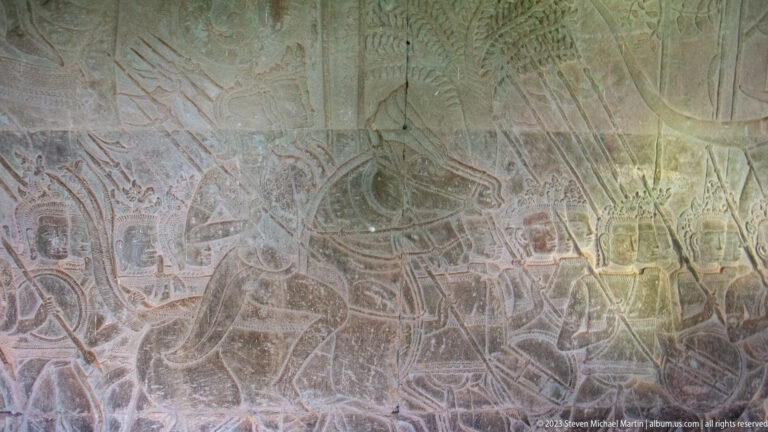 Extensive shallow relief crowded with overlapping human and animal figures at Angkor Wat.