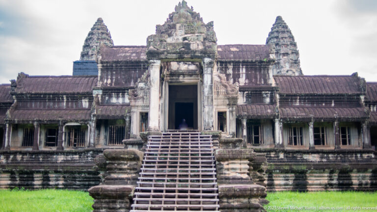Frontal western entrance with broad stair, central doorway, long galleries, and towers at Angkor Wat.