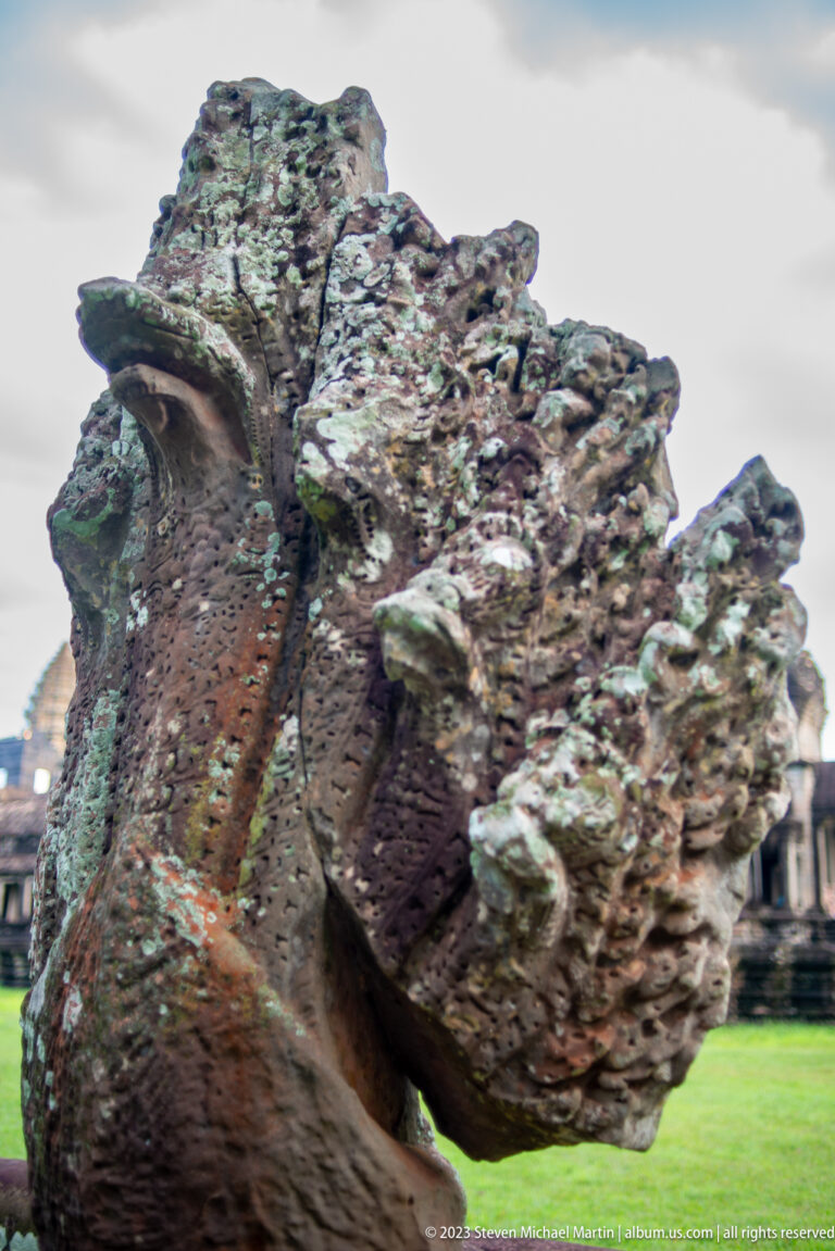 Extreme close-up of an eroded guardian sculpture’s face and surface texture at Angkor Wat.