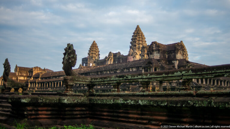 Wide side view of guardian balustrade, galleries, and towers in warm light at Angkor Wat.