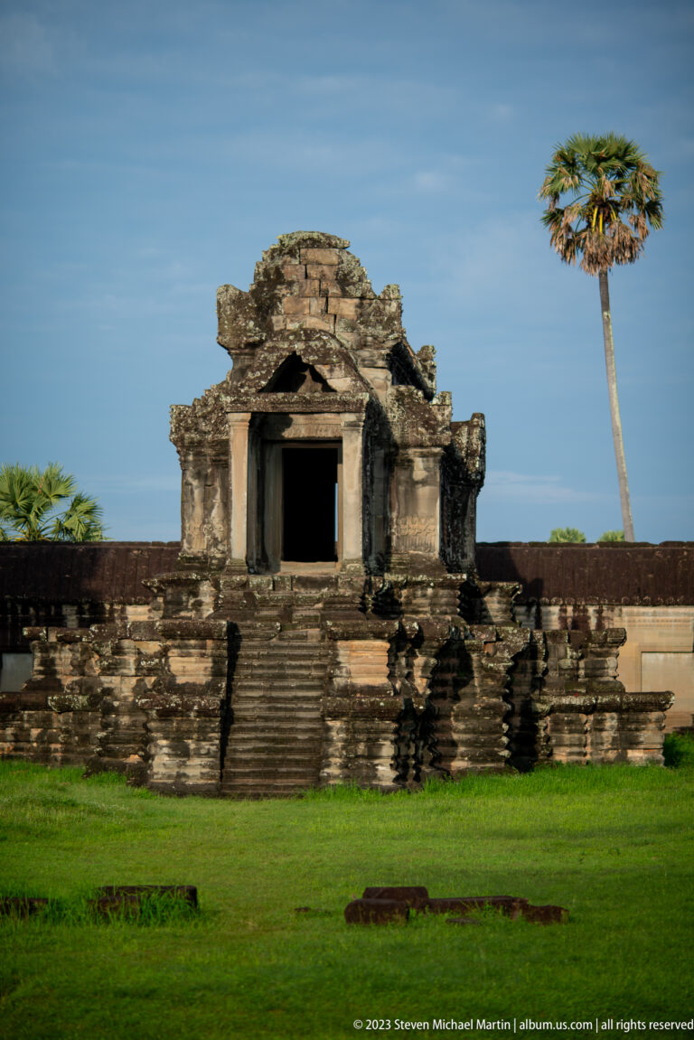 Small elevated shrine or library with central stair and dark doorway at Angkor Wat.
