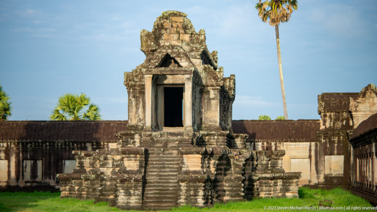 Similar frontal view of the small shrine with a palm rising behind at Angkor Wat.