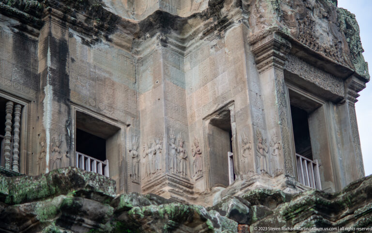 Upward view of a tall plain doorway and massive upper wall at Angkor Wat.
