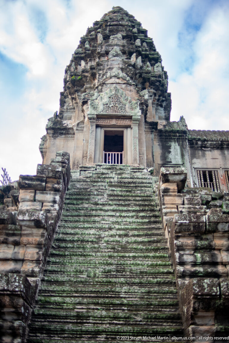 Frontal steep stair leading to a barred upper doorway at Angkor Wat.