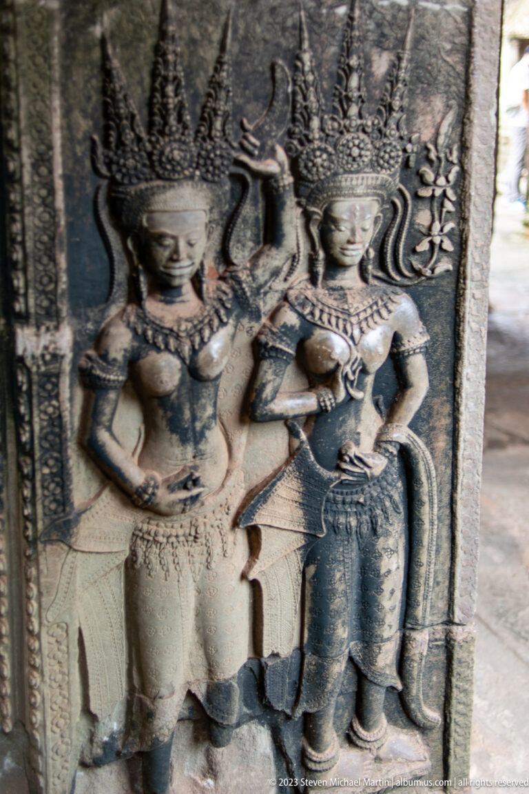 Two richly jeweled devatas in a tight side-by-side relief at Angkor Wat.