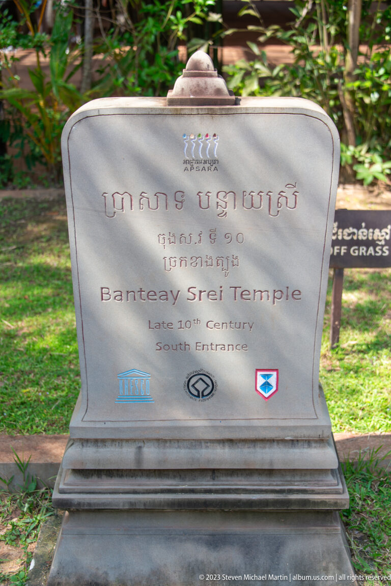 Gray bilingual sign reading Banteay Srei Temple, Late 10th Century, South Entrance.