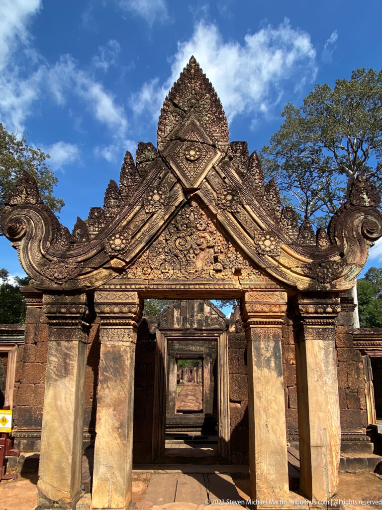 Frontal Banteay Srei gateway framing a sequence of aligned doorways.