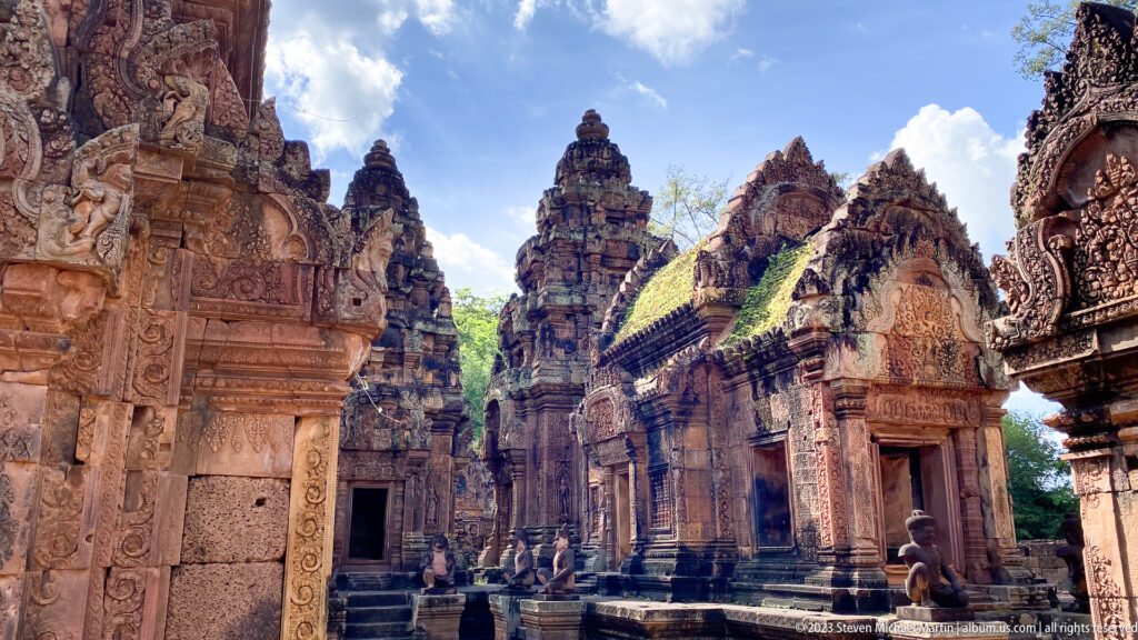 Wide view of clustered carved shrines and towers in the inner enclosure of Banteay Srei.