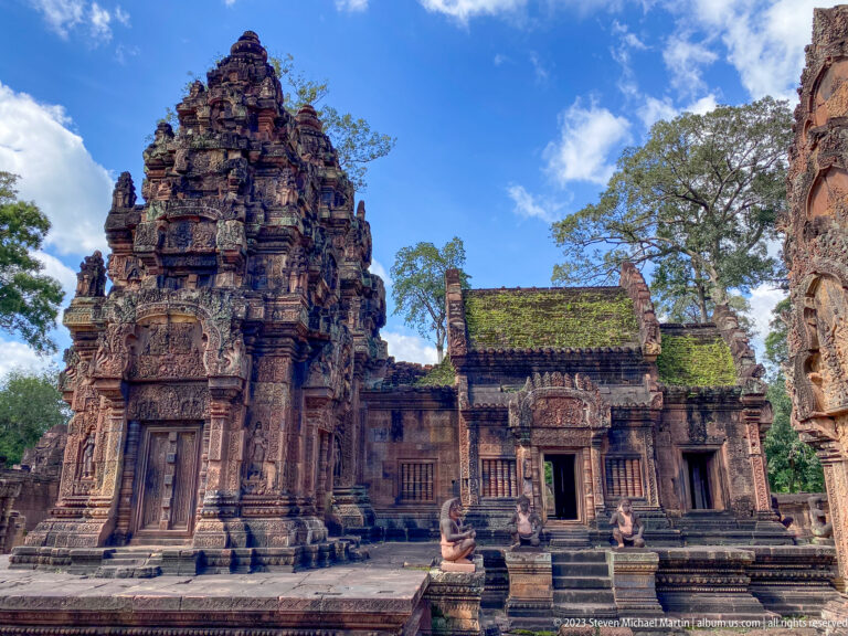 Frontal view of a Banteay Srei sanctuary with central tower, carved façade, and moss-covered roof.