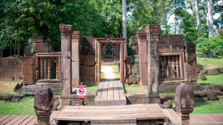 Frontal view of an inner sandstone gateway with columns, baluster windows, and a no-entry sign.