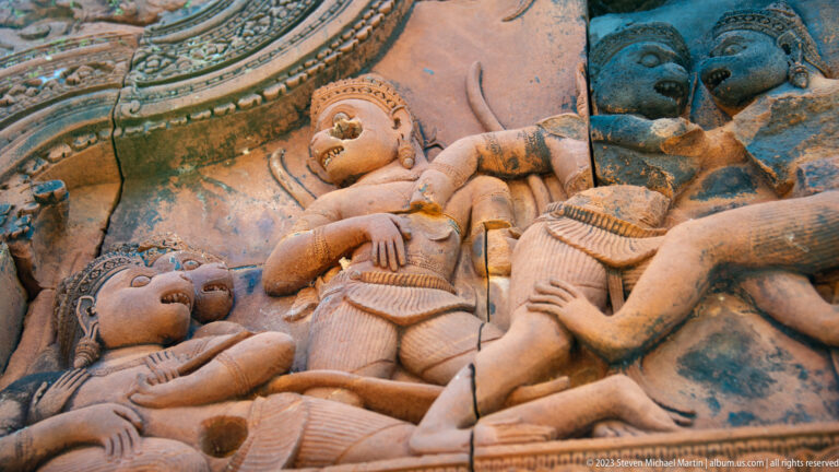 Close sandstone relief of several overlapping figures in a dramatic mythological scene.