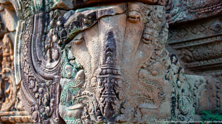 Close carved elephant head with a long descending trunk integrated into sandstone temple ornament.