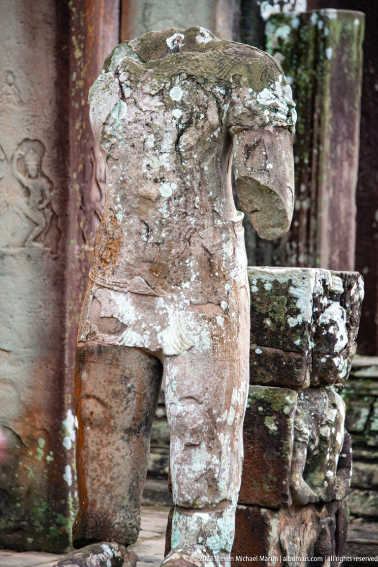 Weathered stone guardian animal with open mouth and lichen-covered body.