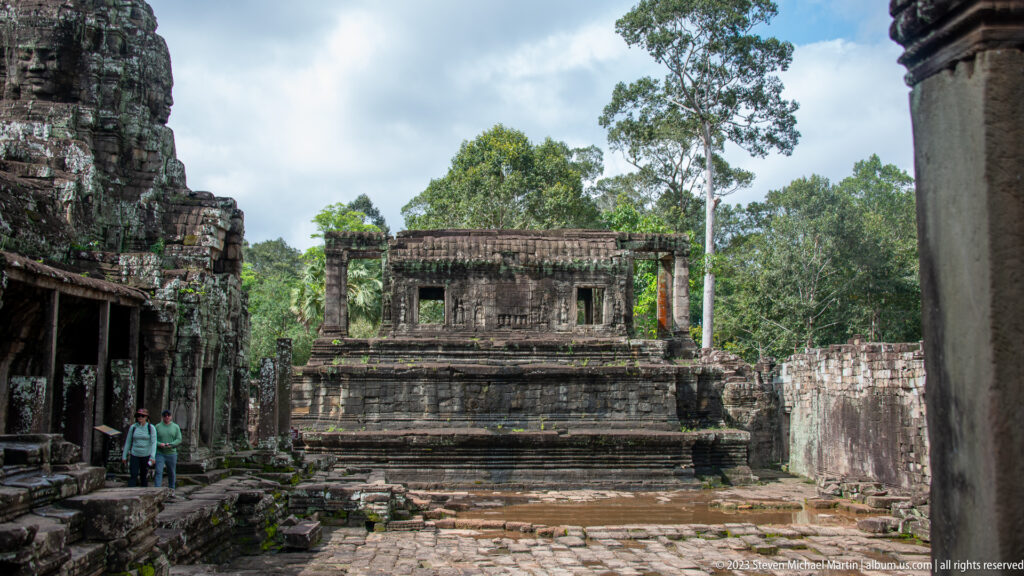 Stone courtyard with weathered galleries and a raised rectangular structure.
