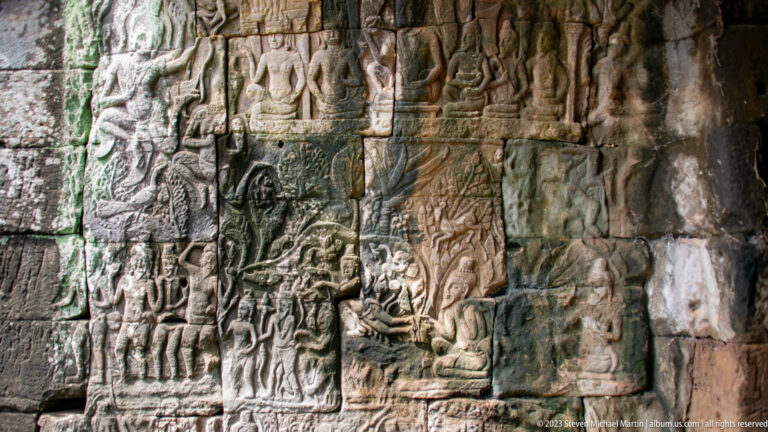 Angled gallery wall covered with dense Khmer narrative bas-reliefs.