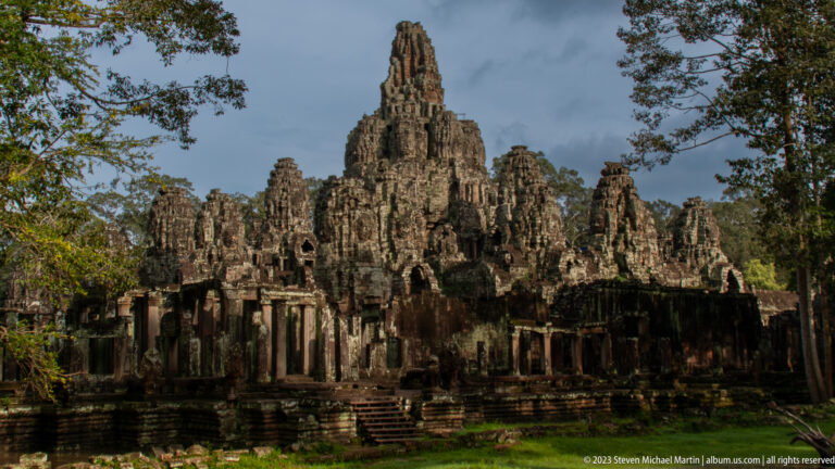 Oblique exterior view of Bayon's central sanctuary and clustered face towers above a long gallery.