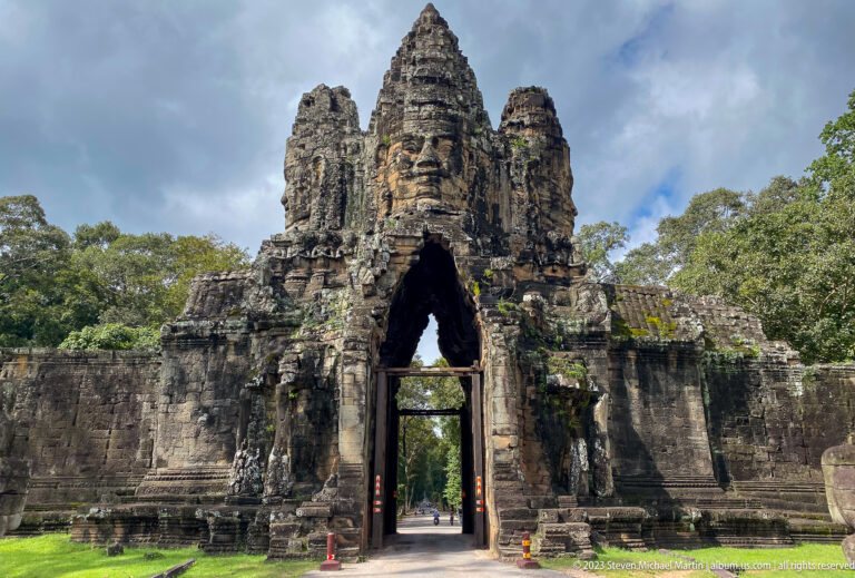 Close frontal view of an Angkor Thom face-tower gate with a pointed passage opening.
