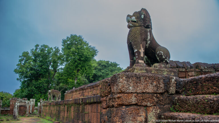 Guardian lion on corner with elephant farther along the wall.